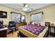 Comfortable bedroom with tile flooring, bright windows, and a ceiling fan at 13814 Lavender Ave, Hudson, FL 34667