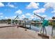 Waterfront view of the boat dock with boat lifts, canal access, and clear skies at 13814 Lavender Ave, Hudson, FL 34667