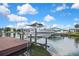 Dock view featuring a boat lift, wood deck, and easy access to the canal at 13814 Lavender Ave, Hudson, FL 34667
