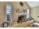Close-up of a brick fireplace with decorative items and natural light streaming in at 13814 Lavender Ave, Hudson, FL 34667
