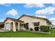 Charming single Gathering home featuring a well-kept lawn, arched entryway, and attached garage at 13814 Lavender Ave, Hudson, FL 34667