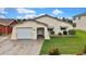 Charming single-story home featuring an attached garage, arched entryway, and manicured lawn at 13814 Lavender Ave, Hudson, FL 34667