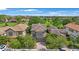 Aerial view of a landscaped home with a brick driveway and beautiful tile roof surrounded by lush greenery at 1391 Marinella Dr, Palm Harbor, FL 34683