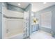Bright, blue bathroom with a tub, shower, gray vanity, and lots of natural light at 1391 Marinella Dr, Palm Harbor, FL 34683