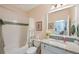 Bright bathroom features a tub with shower and decorative tile accent at 1391 Marinella Dr, Palm Harbor, FL 34683