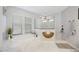 Serene bathroom featuring soaking tub, marble tile, and glass shower at 1391 Marinella Dr, Palm Harbor, FL 34683