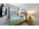 Cozy bedroom with a queen bed, natural light, and stylish decorations at 1391 Marinella Dr, Palm Harbor, FL 34683