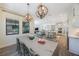 Open-concept dining area with an adjacent view of the kitchen, living room, and large windows at 1391 Marinella Dr, Palm Harbor, FL 34683