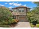 Inviting two-story home with a tile roof, brick driveway, and lush landscaping at 1391 Marinella Dr, Palm Harbor, FL 34683