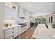 Open kitchen featuring white cabinets, marble countertops, stainless steel appliances, and an adjoining dining area at 1391 Marinella Dr, Palm Harbor, FL 34683