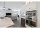 Modern kitchen with stainless steel appliances, a spacious island, and an open view to the living room and staircase at 1391 Marinella Dr, Palm Harbor, FL 34683