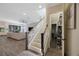 Bright, open-concept living room with modern staircase and light wood-look flooring at 1391 Marinella Dr, Palm Harbor, FL 34683