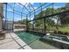 Enclosed pool with views of the golf course, tiled deck, heated spa, and unique stone water feature at 1391 Marinella Dr, Palm Harbor, FL 34683