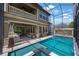 Screened-in pool area featuring a spa, waterfall feature, and an outdoor seating area with plush furniture at 1391 Marinella Dr, Palm Harbor, FL 34683