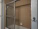 Bathroom featuring a shower/tub with a sliding glass door and neutral-toned tiles at 1510 Palmer Ct, Palm Harbor, FL 34685