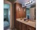 Bathroom featuring wood cabinets, marble counters, a large mirror, and decorative accents at 1510 Palmer Ct, Palm Harbor, FL 34685