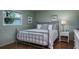 Bright bedroom features a metal bed frame, neutral bedding, and ample natural light at 1510 Palmer Ct, Palm Harbor, FL 34685