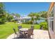 Outdoor patio area featuring a dining table and chairs, backing up to a lush manicured lawn at 1510 Palmer Ct, Palm Harbor, FL 34685