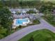 Aerial view of the community pool, surrounded by lush greenery and well-maintained townhomes at 16175 Rambling Vine E Dr, Tampa, FL 33624