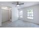 Bright bedroom featuring two large windows, neutral carpet, and ceiling fan at 16175 Rambling Vine E Dr, Tampa, FL 33624