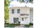 Charming two-story townhouse showcasing white shutters and a covered front porch, offering a cozy curb appeal at 16175 Rambling Vine E Dr, Tampa, FL 33624