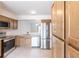Bright kitchen with stainless steel appliances, quartz countertops, and light wood cabinets at 16175 Rambling Vine E Dr, Tampa, FL 33624