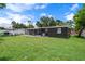 Spacious backyard featuring lush green grass, a screened-in porch and privacy fence at 1707 Windsor Way, Tampa, FL 33619