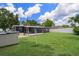 Expansive backyard featuring a screened in porch and storage unit at 1707 Windsor Way, Tampa, FL 33619