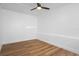 Bright bedroom featuring hardwood floors, white walls, and a ceiling fan at 1707 Windsor Way, Tampa, FL 33619