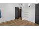 Bedroom with hardwood floors, white walls, and a dark closet with wall lighting at 1707 Windsor Way, Tampa, FL 33619