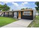 Well-maintained single story home with a lush green lawn, inviting front door, and freshly sealed driveway at 1707 Windsor Way, Tampa, FL 33619