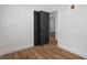 Hallway leading to a bright room featuring hardwood floors, white walls, and a dark closet at 1707 Windsor Way, Tampa, FL 33619