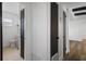 Hallway with hardwood floors, modern doors and access to a bathroom with tile floors at 1707 Windsor Way, Tampa, FL 33619