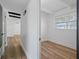Hallway leading to a bright room featuring hardwood floors, white walls, and large windows at 1707 Windsor Way, Tampa, FL 33619