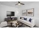 Cozy living room featuring a ceiling fan, plush seating, modern decor and a large television at 1707 Windsor Way, Tampa, FL 33619