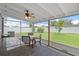 Relaxing screened porch with seating, fan and view of the backyard at 1707 Windsor Way, Tampa, FL 33619