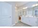 Bright bathroom features a glass shower, white cabinets, and double sinks at 17140 Holly Well Ave, Wimauma, FL 33598