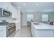 Bright kitchen features stainless steel appliances, granite countertops, and tile flooring at 17140 Holly Well Ave, Wimauma, FL 33598