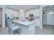 Bright kitchen with white cabinetry, stainless steel appliances, and a center island with bar seating at 17140 Holly Well Ave, Wimauma, FL 33598
