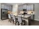 Stylish kitchen featuring gray cabinets, stainless steel appliances, and a breakfast bar with seating at 17140 Holly Well Ave, Wimauma, FL 33598