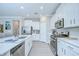 Modern kitchen featuring white cabinets, stainless steel appliances, and a center island with seating at 17140 Holly Well Ave, Wimauma, FL 33598