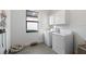 Bright laundry room with a side-by-side washer and dryer, and overhead storage cabinets at 17140 Holly Well Ave, Wimauma, FL 33598