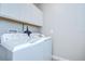 Laundry room with white washer and dryer and white cabinets above at 17140 Holly Well Ave, Wimauma, FL 33598