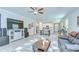 Open-concept living room with stylish decor, wood-look tile floors, and abundant natural light at 17140 Holly Well Ave, Wimauma, FL 33598