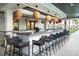 Stylish outdoor bar area with modern seating, granite countertop, and overhead lighting at 17140 Holly Well Ave, Wimauma, FL 33598