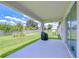 Covered patio overlooking a spacious backyard with green grass and landscaping at 17140 Holly Well Ave, Wimauma, FL 33598