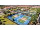Aerial view of pickleball courts featuring multiple courts and manicured landscaping at 17140 Holly Well Ave, Wimauma, FL 33598