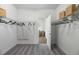 Spacious walk-in closet with ample shelving and storage space, featuring white walls and carpet flooring at 17140 Holly Well Ave, Wimauma, FL 33598