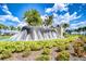 Picturesque water feature surrounded by lush tropical landscaping and palm trees against a blue sky at 17140 Holly Well Ave, Wimauma, FL 33598