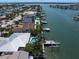 This aerial shows a canal-front home with a private pool and dock at 202 Howard Dr, Belleair Beach, FL 33786